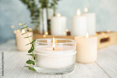 Fotografie, Obraz Burning aromatic candle and eucalyptus branch on table