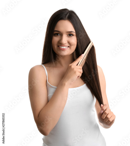 Beautiful young woman with hair comb on white background