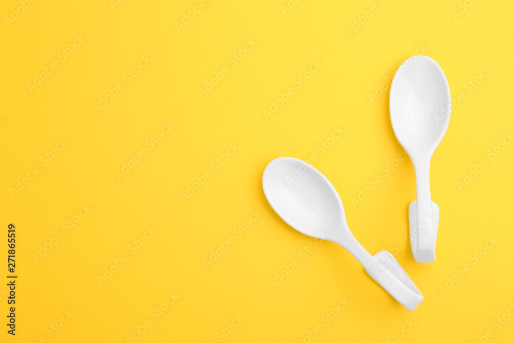 Clean ceramic appetizer spoons and space for text on color background, flat lay Clean ceramic appetizer spoons and space for text on color background, flat lay