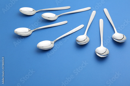 Composition with clean tablespoons on color background