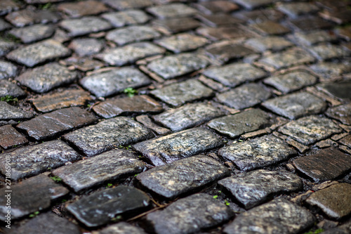 Stone pavement texture. Granite cobblestoned pavement background. Cobbled stone road regular shapes, abstract background of old cobblestone pavement close-up. 