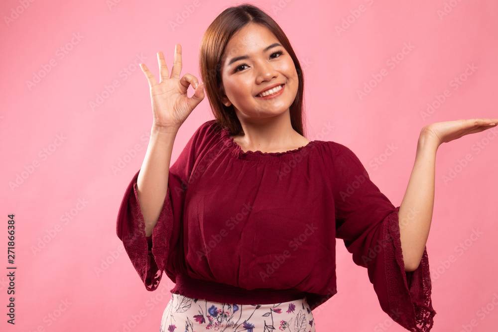 Beautiful young Asian woman show palm hand and OK sign. Beautiful young Asian woman show palm hand and OK sign.