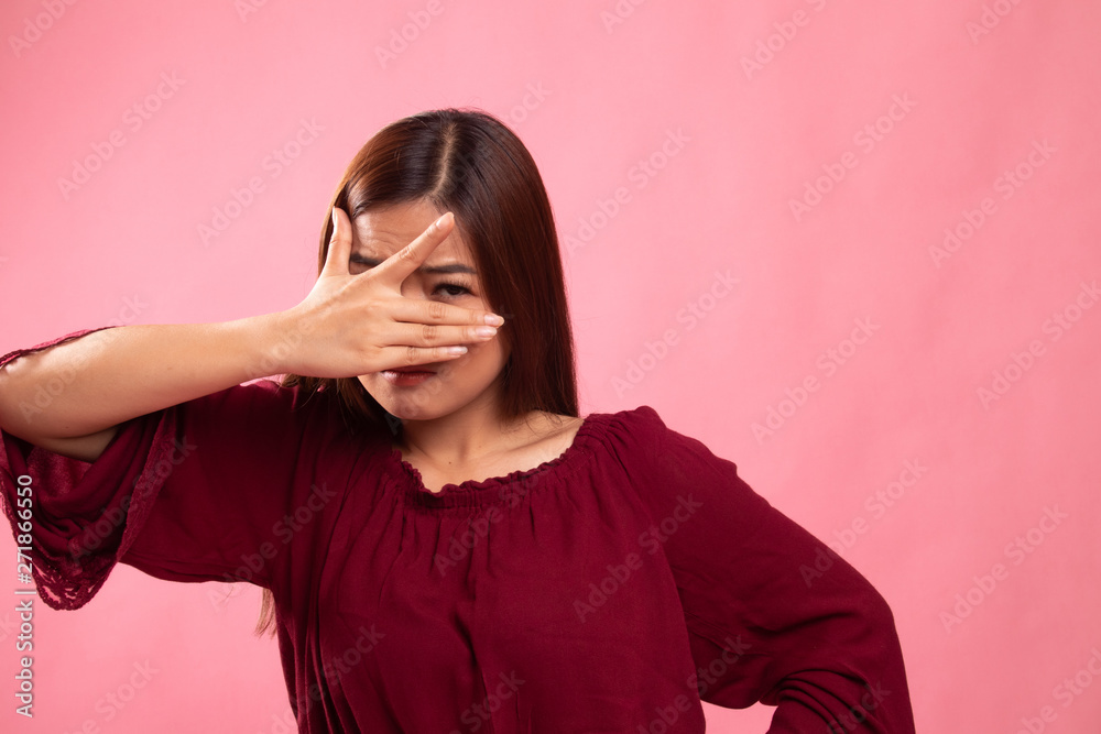 Beautiful young Asian woman peeking through fingers. Beautiful young Asian woman peeking through fingers.