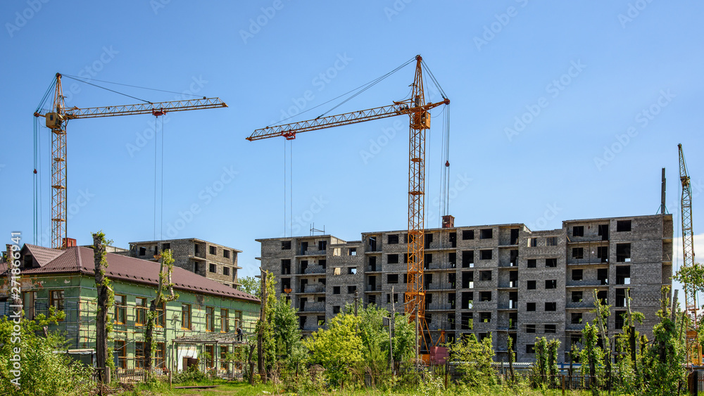 construction site of a residential multi-storey building with tower cranes