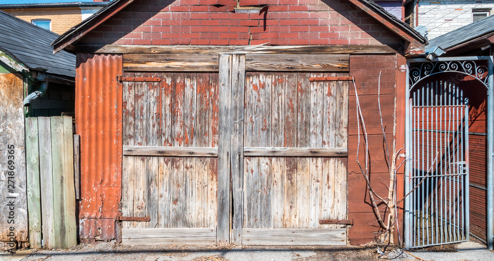 Old rustic and weathered garage and wrought iron gateway Old rustic and weathered garage and wrought iron gateway