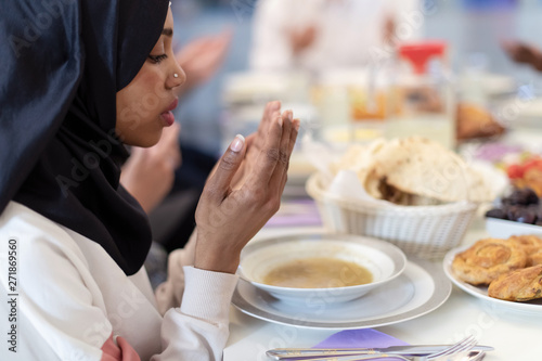 modern black muslim woman praying before having iftar dinner