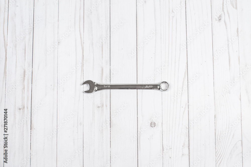 Tools, wrench on a white wooden background