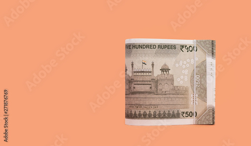 Folded set of Indian 500 Rupee currency bills isolated on Apricot background photo