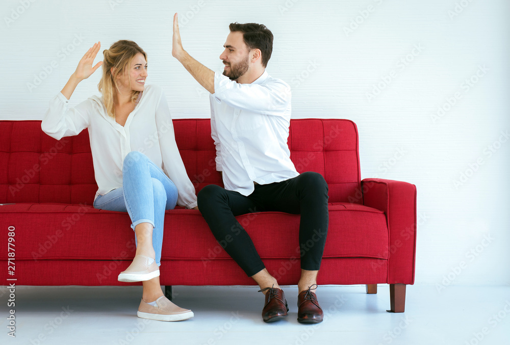 Couple lover hand clapping feeling happy and sitting on sofa at home,Cheerful and attractive people