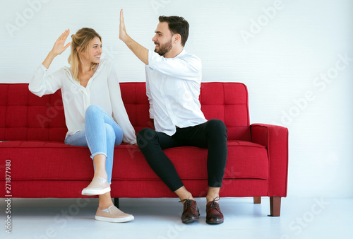 Couple lover hand clapping feeling happy and sitting on sofa at home,Cheerful and attractive people