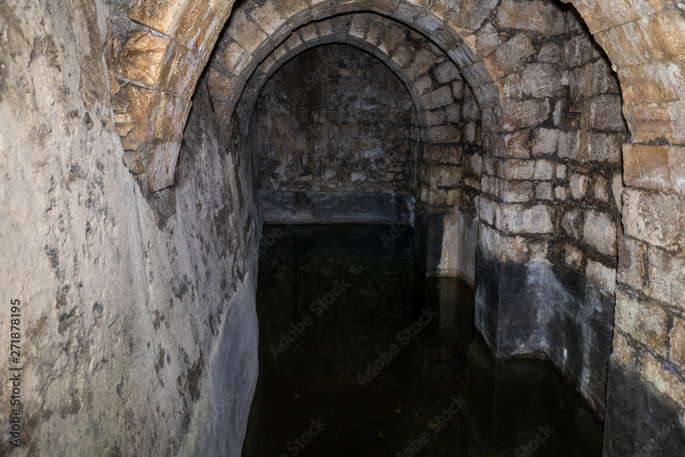 Surviving underground reservoir partially filled with water in ancient ruins of Pools of Bethesda in the old city of Jerusalem, Israel