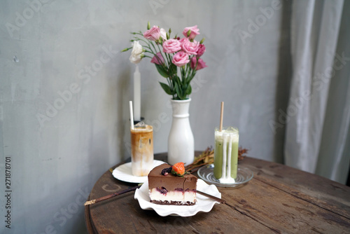 Set of Homemade black forest mousse cake mixed with mascarpone cheese, Iced coffee latte and Iced matcha green tea latte on wooden table and blurred background.