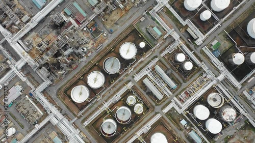 Aerial top down view over oil refinery and power plant with many storage tanks and pipelines. Shot with 4K UHD resolution drone