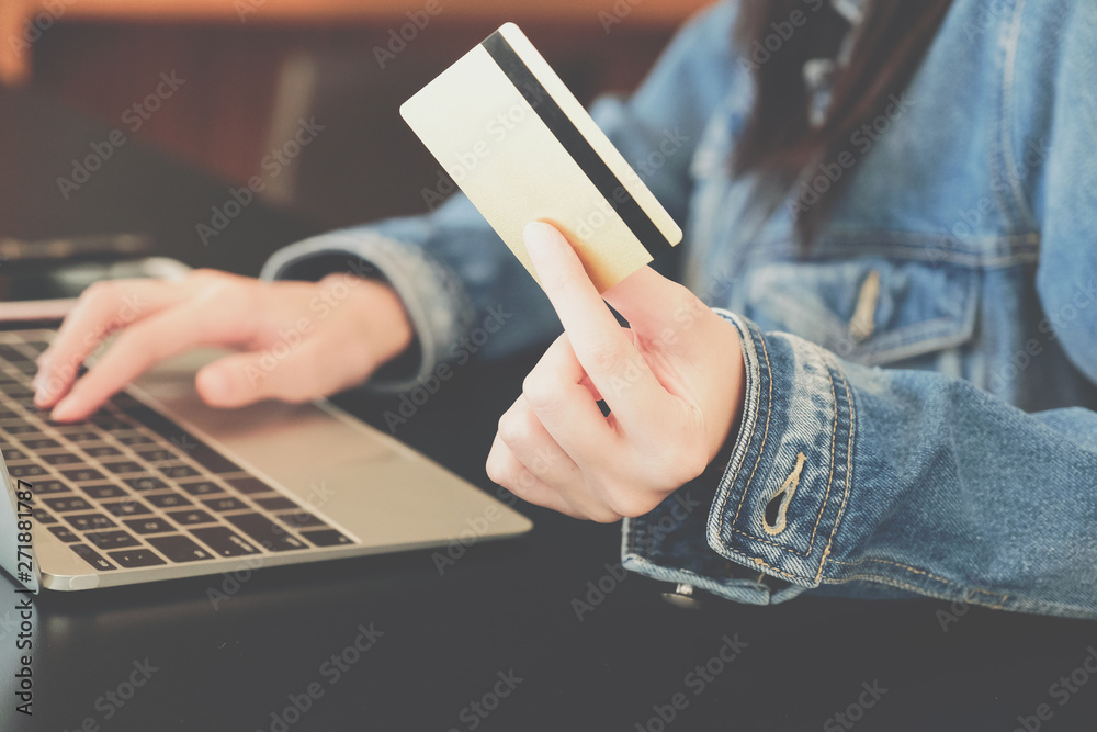 woman holding credit card using computer for shopping online woman holding credit card using computer for shopping online