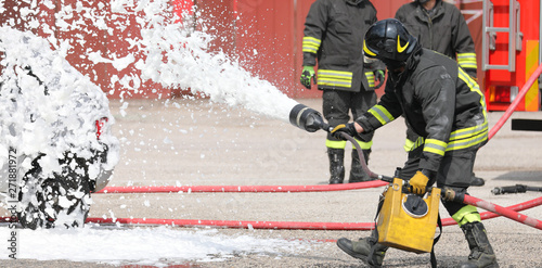 firefighter with foam the car after road accident