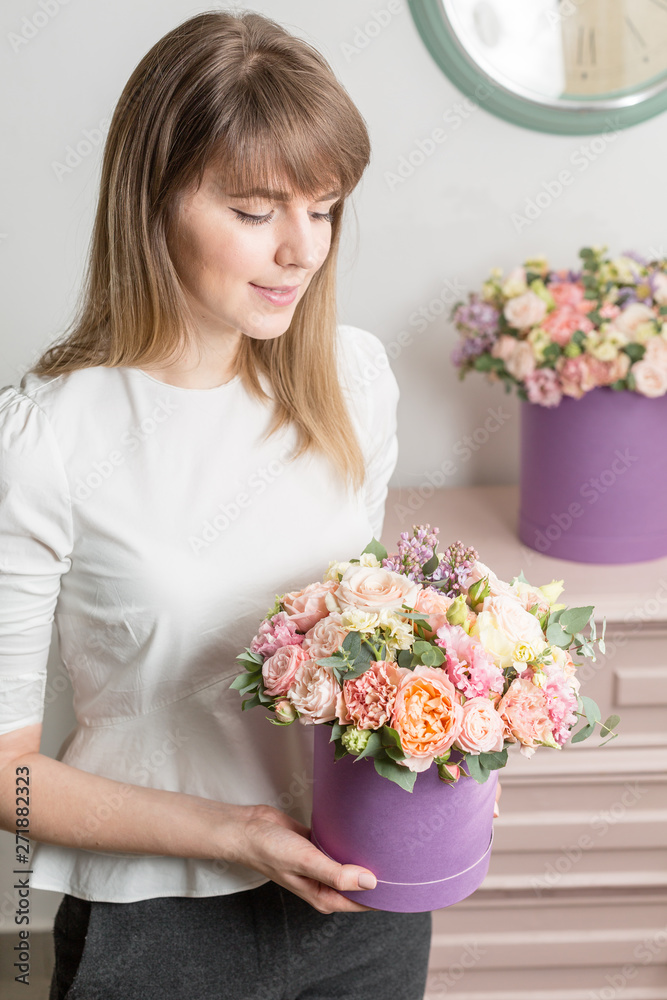 Florist holding a bouquet. Beautiful spring flowers in head box. Arrangement with mix flowers. The concept of a flower shop, a small family business. Work florist.