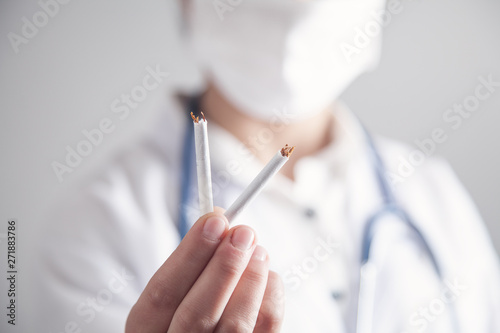 Doctor holding broken cigarette. Stop smoking