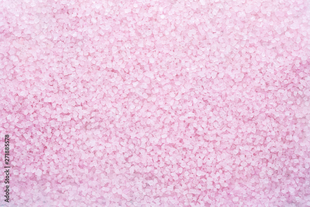 Light pink crystals of mineral bath salts as background. Flat lay.