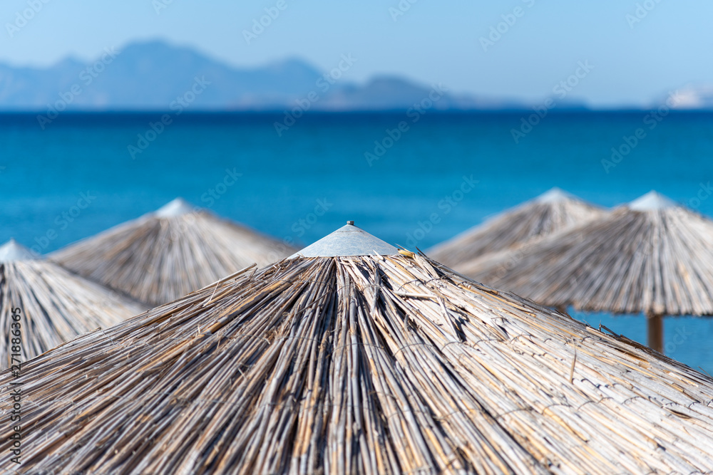 Umbrellas on Kardamena city beach in Kos island, Greece.