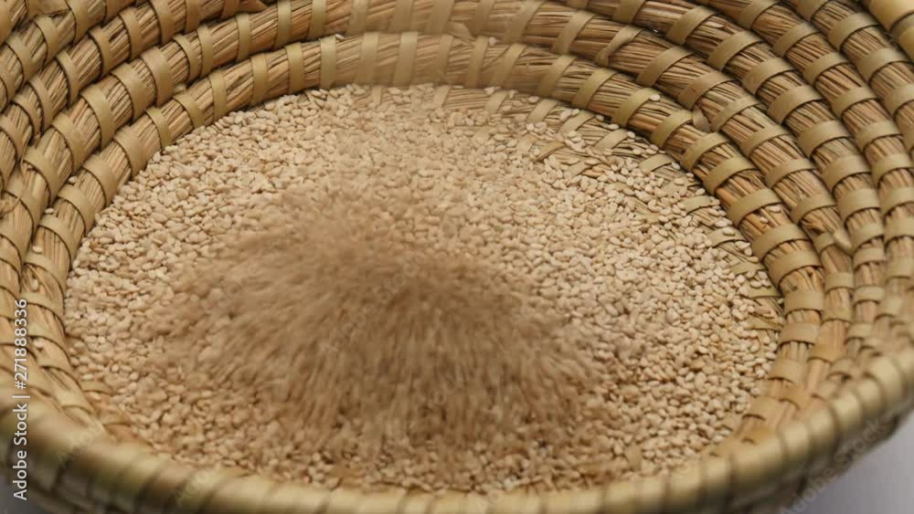Falling Sesame seeds on a weave wicker basket