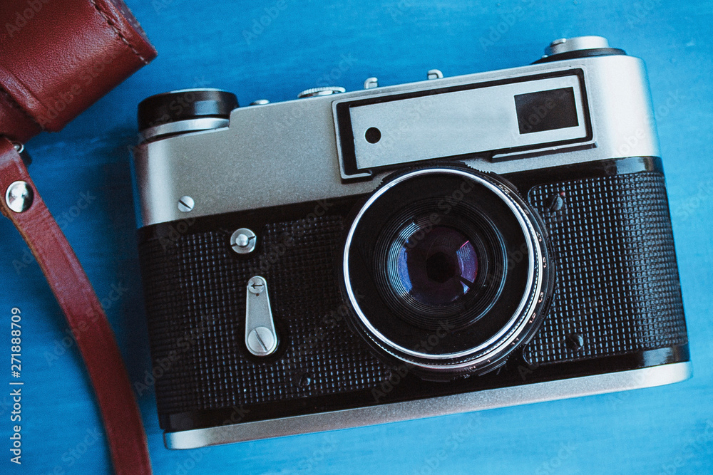  Film camera on a blue background. Retro camera.