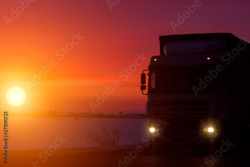 Silhouette Truck with container on highway  cargo transportation concept. Sunset background with copy space