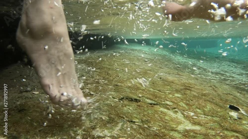 Woman feet taping the water, underwater shot photo