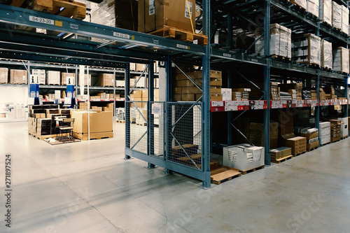Large wharehouse with rows of shelves and goods boxes.