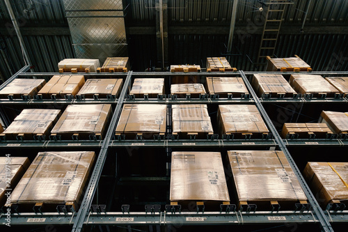 Large wharehouse with rows of shelves and goods boxes.