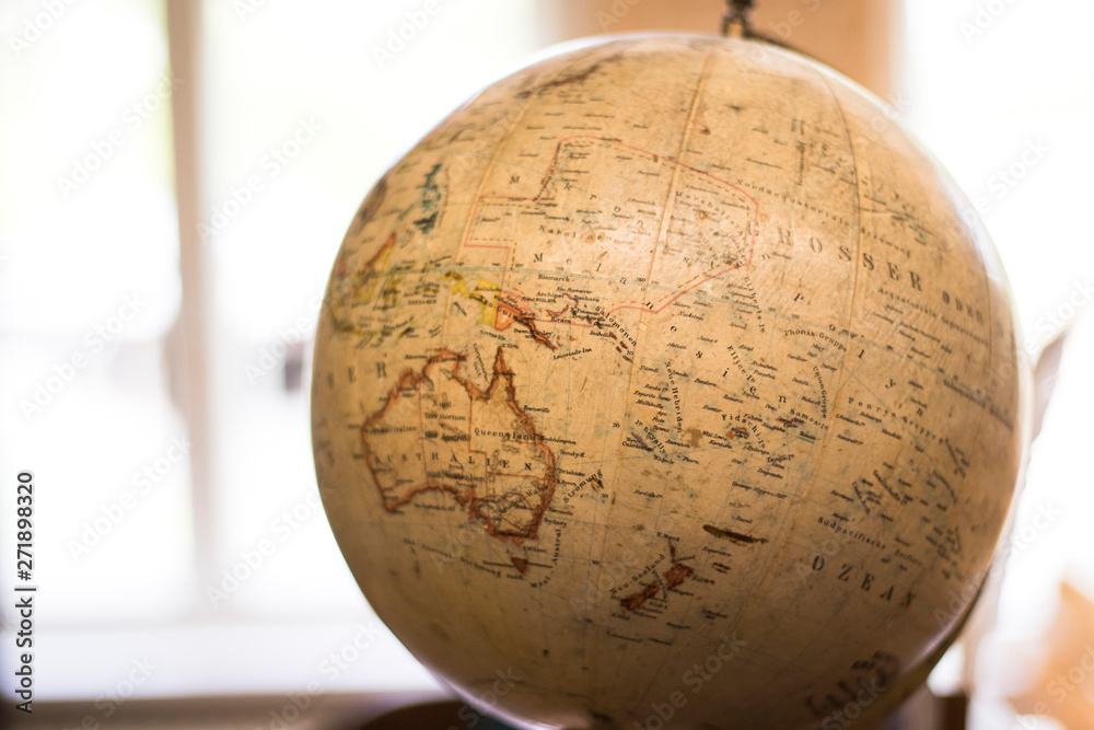 An antique globe in front of a bright window. An antique globe in front of a bright window.