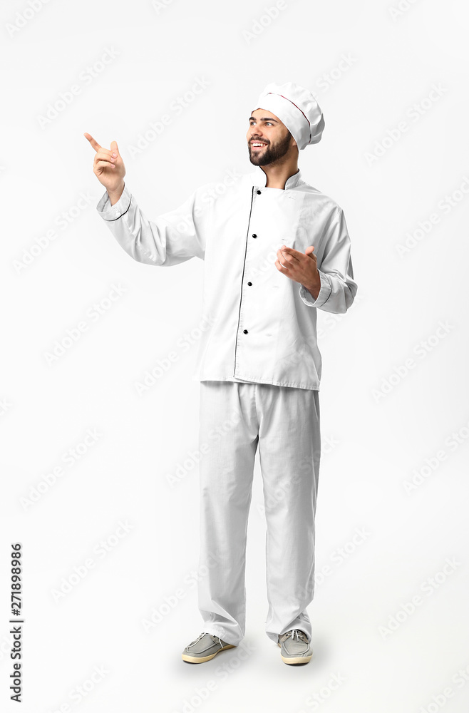 Handsome male chef pointing at something on white background Handsome male chef pointing at something on white background