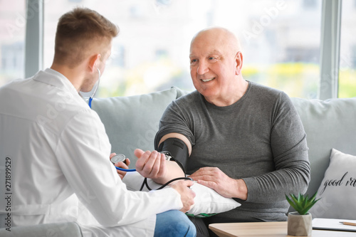 Doctor examining senior man...