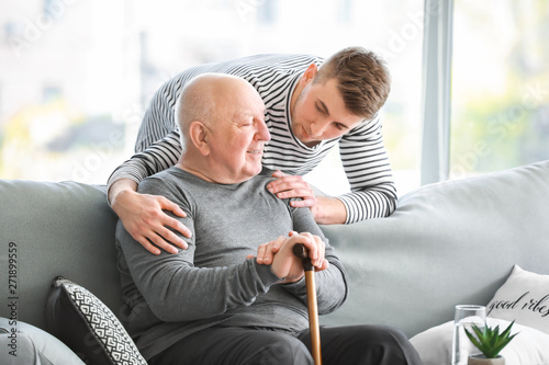 Male caregiver with senior man in nursing home photo