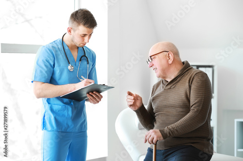 Doctor examining senior man...