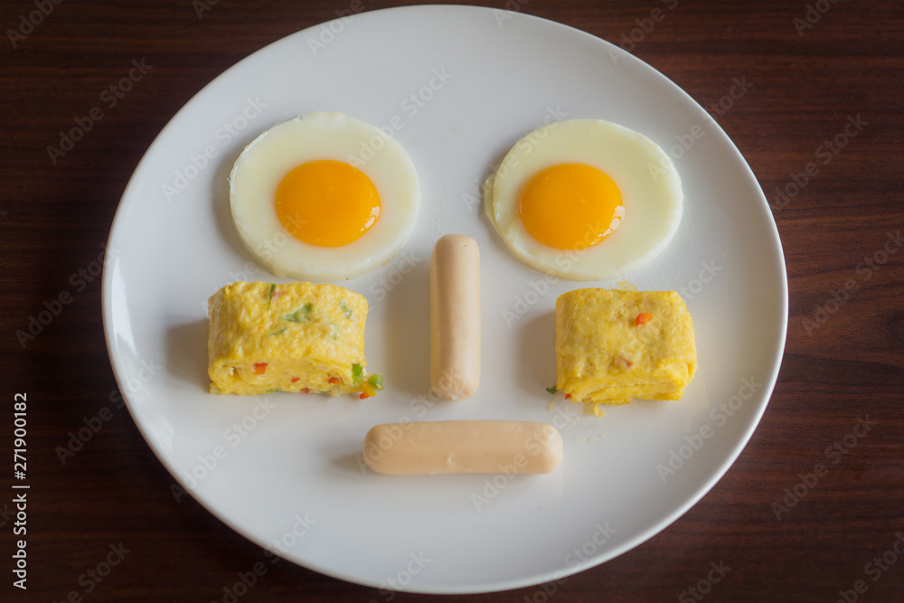 Food face on a plate. It consists of fried eggs, sausages and omelets. Food face on a plate. It consists of fried eggs, sausages and omelets.