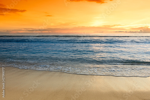 Sunset over sandy ocean beach