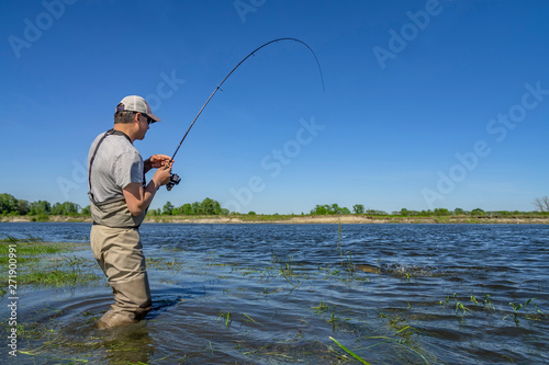 Big pike fishing. Fisherman catch fish in water at river