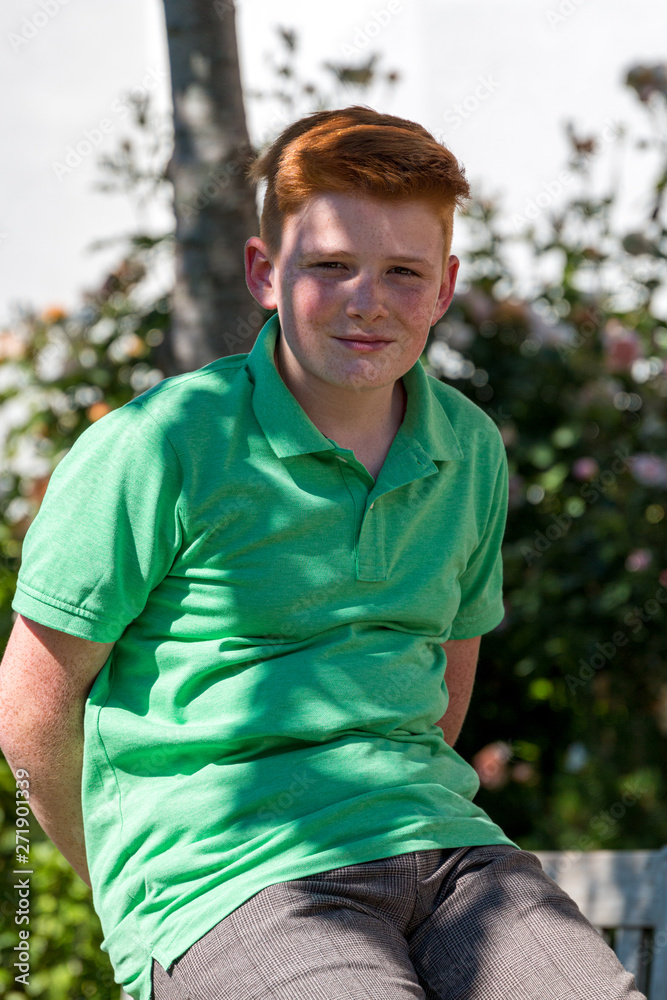 red-haired teen sitting on a stone