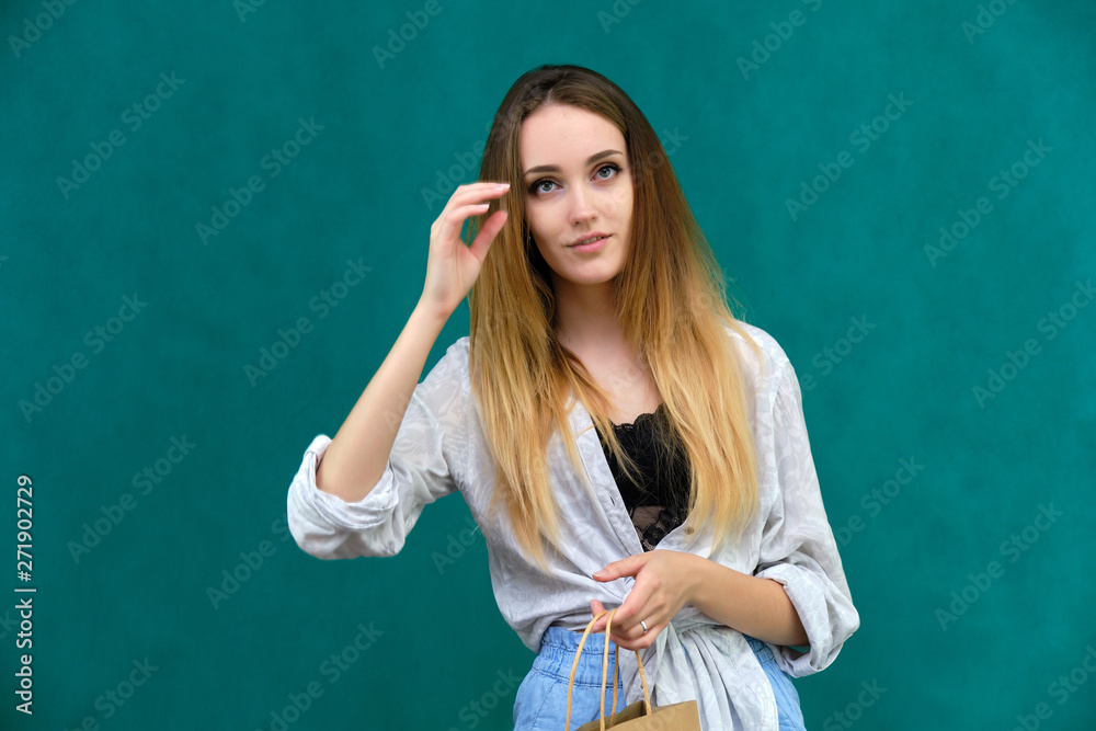 Picture a portrait of a beautiful girl woman with long dark flowing hair, fashionable, on a green background sitting on a wooden staircase. She sits in different poses and smiles.