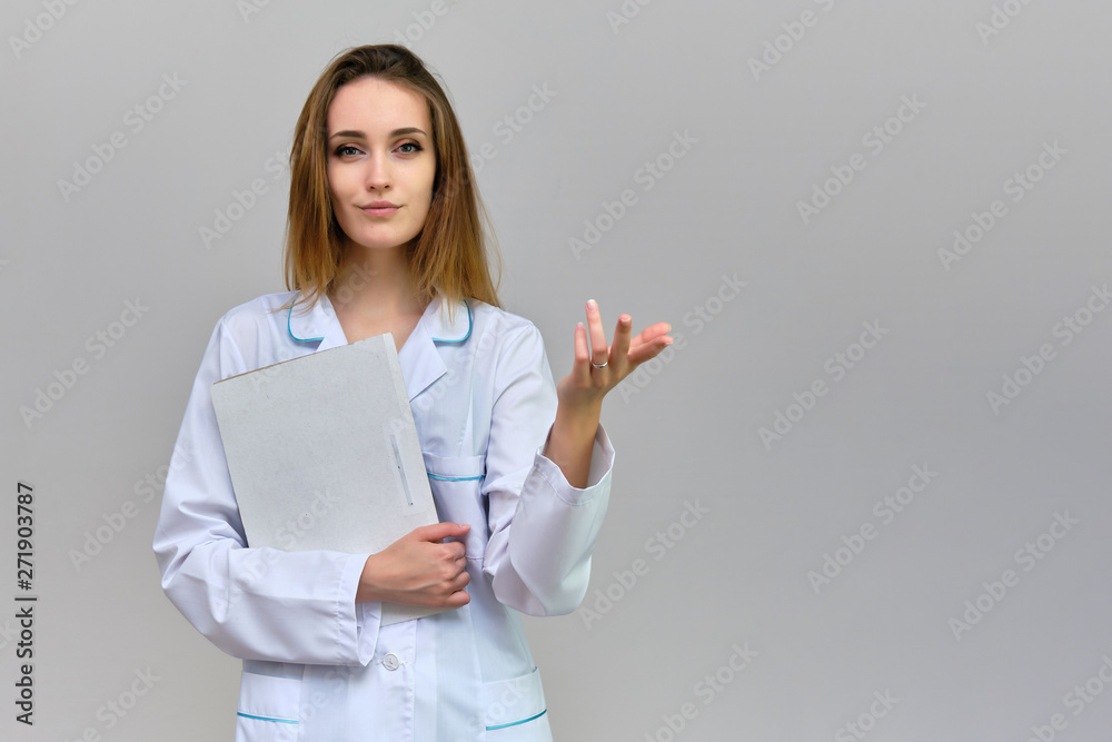 Photograph of a portrait of a beautiful girl doctor woman with long dark flowing hair, on a gray background with a folder in her hands. She is standing in different poses and smiling. Photograph of a portrait of a beautiful girl doctor woman with long dark flowing hair, on a gray background with a folder in her hands. She is standing in different poses and smiling.