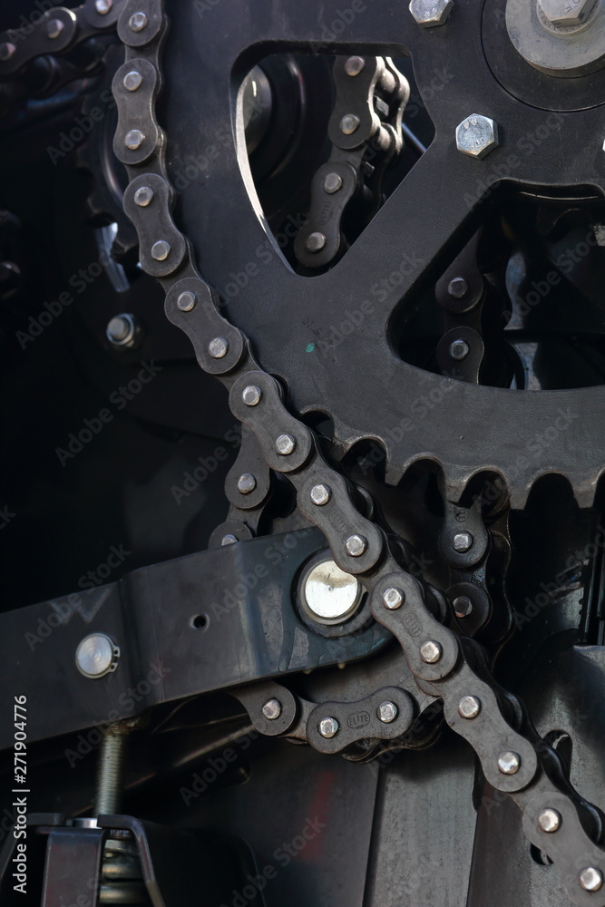 Transmission agricultural machinery. Sprockets, chain drives and springs are visible. Close-up.