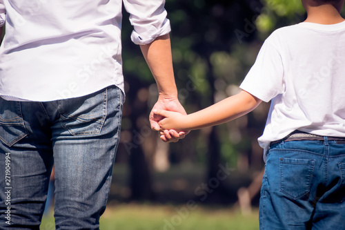 Father and daughter walking in the park holding hands. We will love and take care of you forever concept.  © Chinnachote