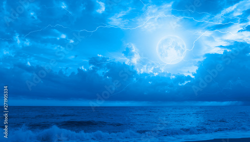 Night sky with full moon in the clouds on the background lightning "Elements of this image furnished by NASA