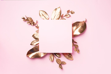 Golden leaves on pink background with copy space. Top view. Copy space. Summer and autumn concept. Creative design elements for invitation, wedding cards, valentines day, greeting cards.