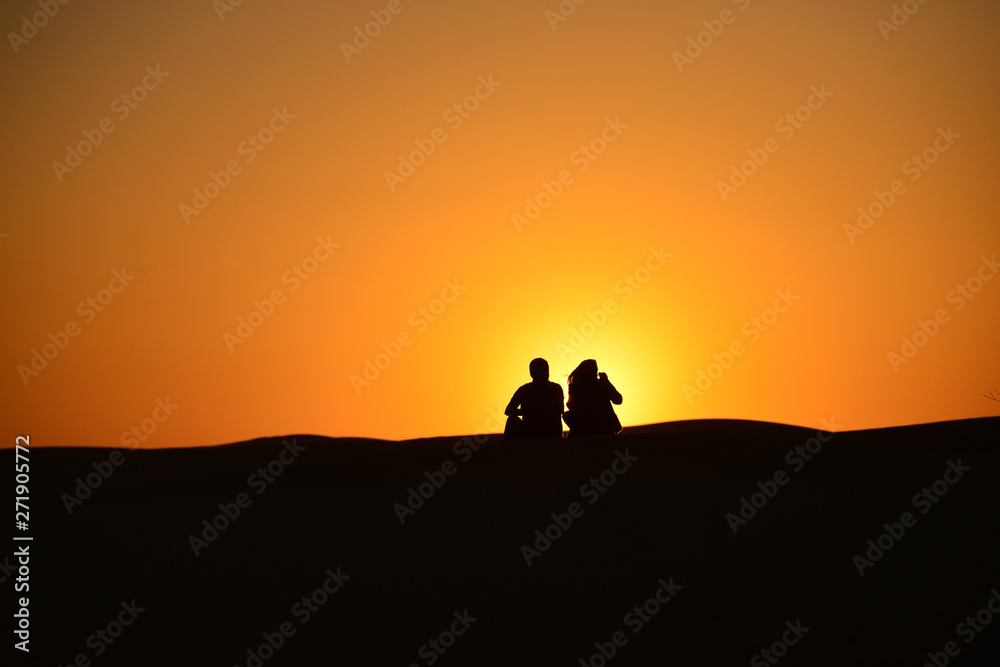 Silhouettes at sunset in the Arabian desert 