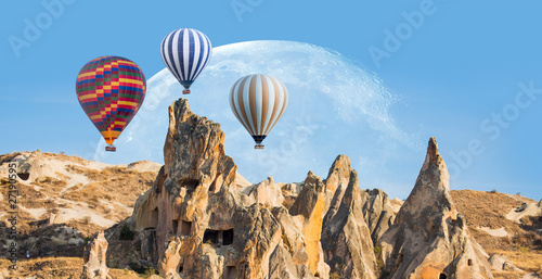 Hot air balloon flying over spectacular Cappadocia with full moon "Elements of this image furnished by NASA - Goreme, Turkey