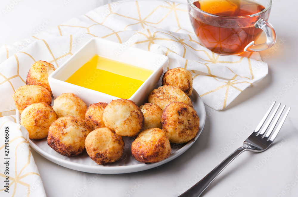Delicious fried cheese balls served with honey and cup of black tea.Set of tasty breakfast Delicious fried cheese balls served with honey and cup of black tea.Set of tasty breakfast