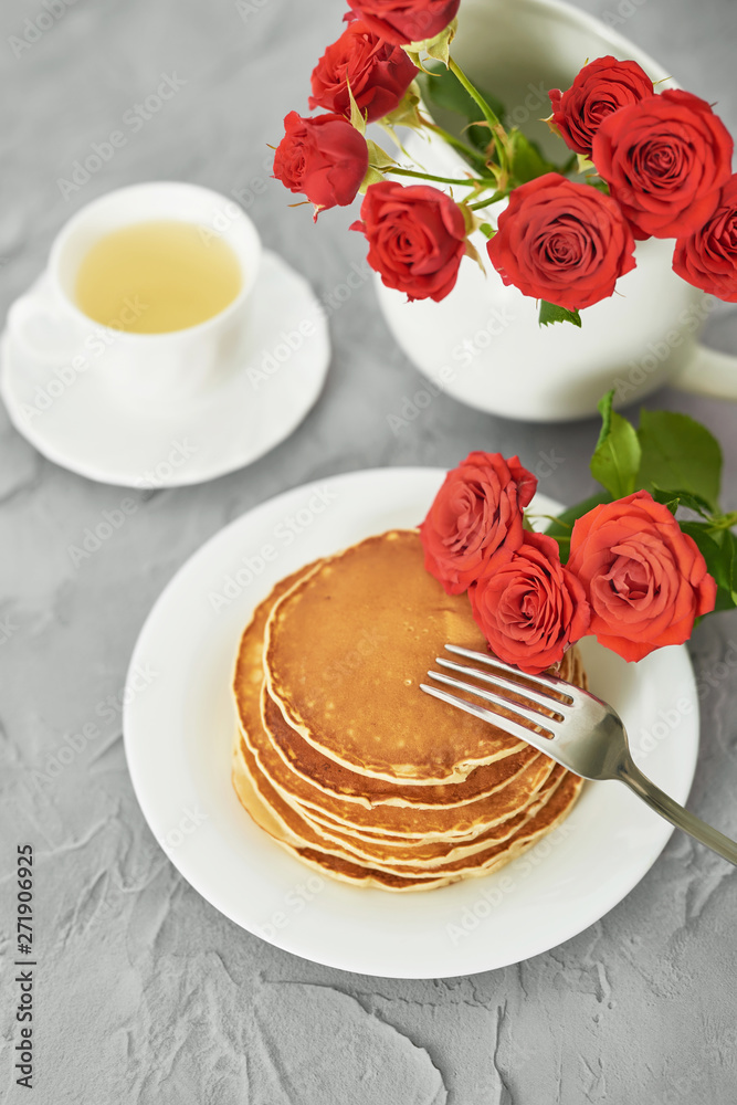 Independence Day on July 4th, American pancakes on the table next to the crockery and red roses. Independence Day on July 4th, American pancakes on the table next to the crockery and red roses.