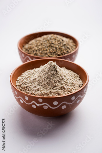 Bajra (pearl millet) / sorghum grains with it's flour or powder in a bowl, selective focus © Arundhati
