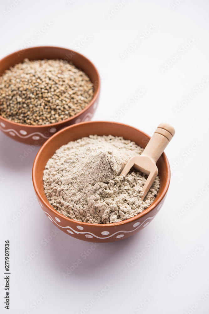 Bajra (pearl millet) / sorghum grains with it's flour or powder in a bowl, selective focus Bajra (pearl millet) / sorghum grains with it's flour or powder in a bowl, selective focus
